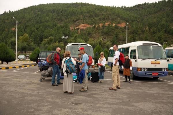 Tour vehicles and travellers on a road in Bhutan